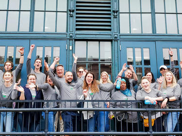 A group of people smiling and waving on impact day 2022