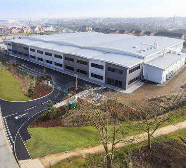 Aerial view of SEM headquarters at The Bridge in Dartford, England, still in construction with trees and green lawn