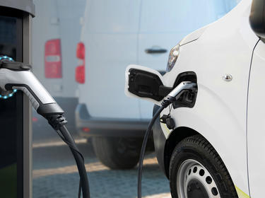 White van using EV charging station