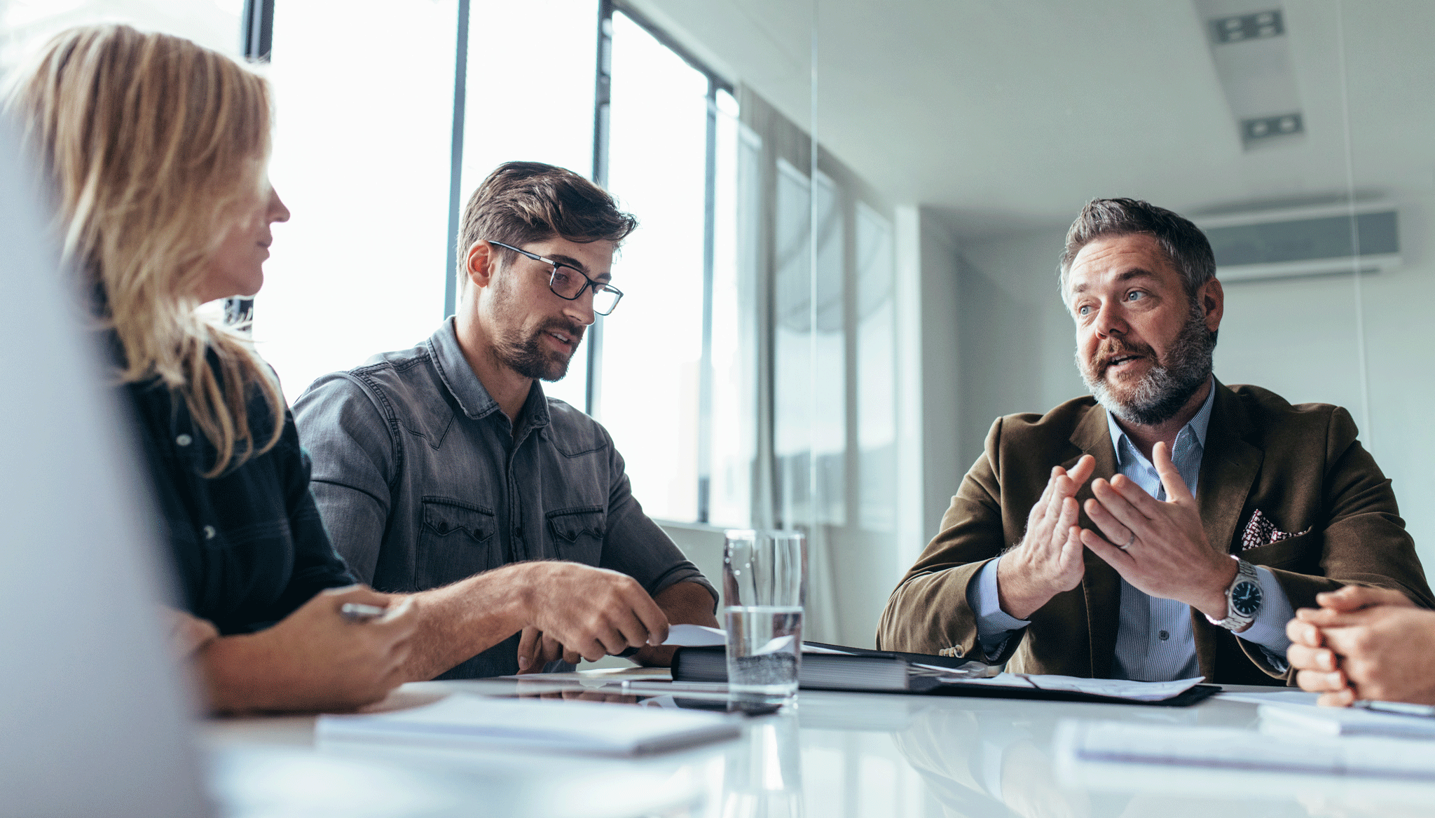 Three people sitting around a table and talking